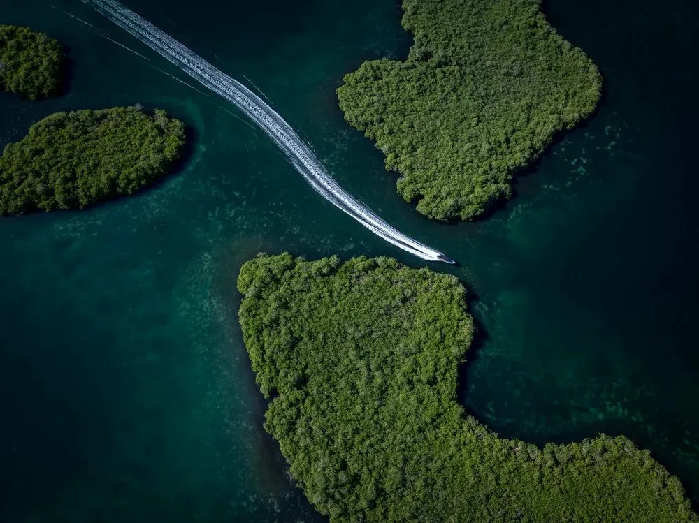 Aerial boat passing between islands.